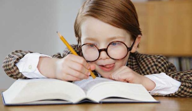 Boy businessman writing in book