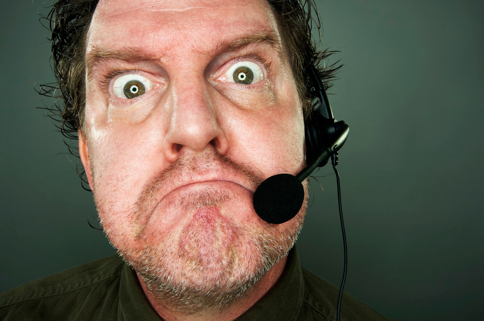 Frowning man with telephone headset.