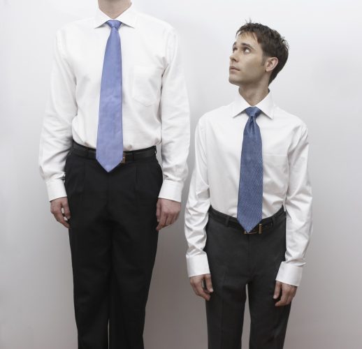 Short business man standing next to tall man