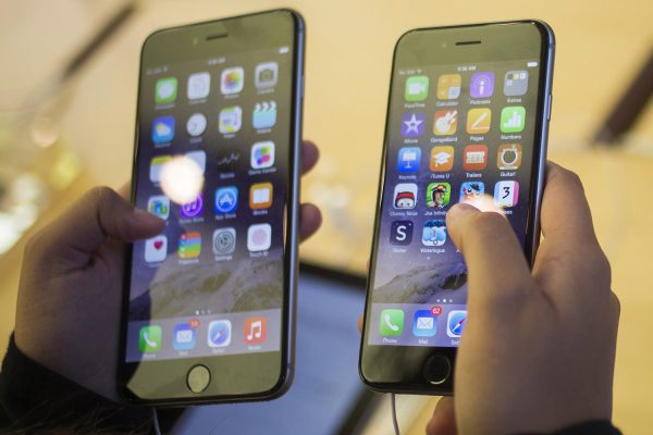 A customer holds an iPhone 6 (R) and iPhone 6 Plus at the Apple store on Fifth Avenue after the phones went on sale in New York in this file photo taken September 19, 2014. Apple Inc said it sold a record 10 million iPhones in the first weekend after its new, larger phone models went on sale in 10 countries on Friday. REUTERS/Adrees Latif/Files (UNITED STATES - Tags: BUSINESS SCIENCE TECHNOLOGY TELECOMS)