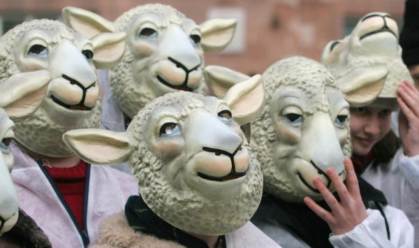 Demonstrators wearing sheep masks demons