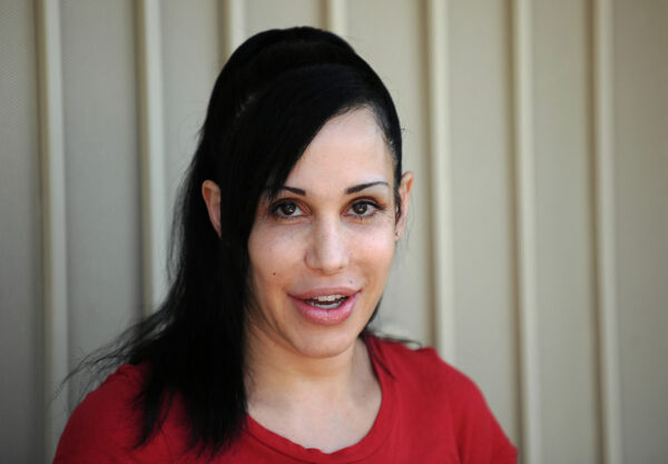 "Octomom" Nadya Suleman poses for photographers in front of her home in La Habra, California on May 19, 2010. Suleman who has been facing possible home forclosure agreed to display a banner for Peta who offered to give her $5,000 USDand a month's worth of free veggie dogs and veggie burgers. AFP PHOTO / GABRIEL BOUYS (Photo credit should read GABRIEL BOUYS/AFP/Getty Images) ** TCN OUT ** ORG XMIT: 99302088