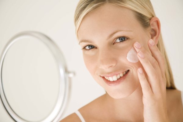 Woman applying moisturizer