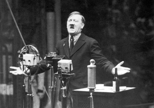 Nazi leader Adolf Hitler speaks in front of microphones and gestures with his hands.-newline-newlineFrom the newsreel 'The March of Time'. [1935] Credit: Hulton|Archive by Getty Images