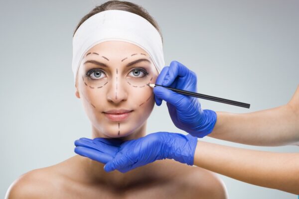 Beautiful woman with plastic surgery, depiction, plastic surgeon hands
