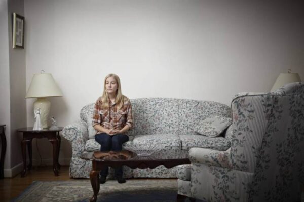 A lone girl on a couch.