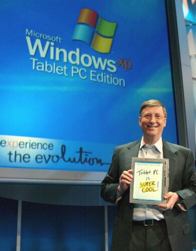 Bill Gates, chairman and chief software architect of Microsoft, holds a Table PC at the product launch event in New York City, November 7, 2002. Tablet PCs combine the full power of the Windows XP Tablet PC Edition operating system with the capability to use a digital pen in addition to a keyboard or mouse. The result is a computer that can be used more often, and in more places, than traditional notebook PCs. Photo by Jeff Christensen