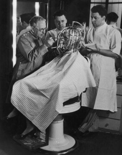 Hollywood cosmetics expert Max Factor (1877 - 1938, left) takes precise measurements of a young woman's head and face with a 'Beauty Calibrator', device, circa 1932. The device is intended to detect subtle facial characteristics, which need to be disguised or enhanced for the screen with make up. (Photo by FPG/Hulton Archive/Getty Images)