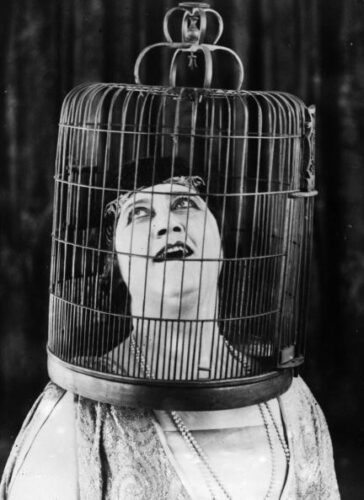 circa 1930: Opera singer at the New York Met, Marie Tiffany singing 'like a bird' with her head in a bird cage ! (Photo by General Photographic Agency/Getty Images)