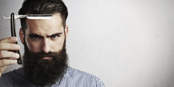 Portrait of bearded man with vintage straight razor