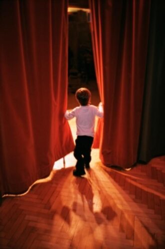 Boy Opening Theater Curtains