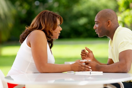 Couple sitting at outdoor table, talking