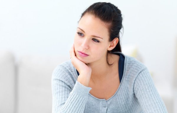 Closeup portrait of a young woman sitting with her hands on desk