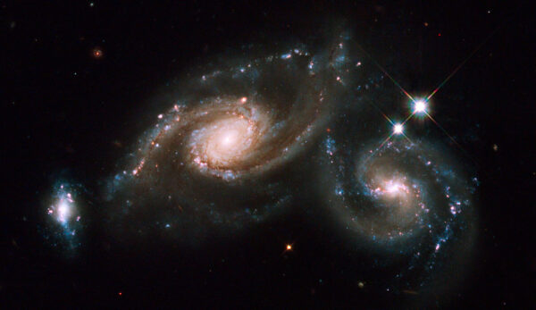 In celebration of the International Year of Astronomy 2009, the NASA/ESA Hubble Space Telescope photographed the winning target in the Space Telescope Science Institute's "You Decide" competition. The image of the winner, a group of interacting galaxies called Arp 274, was revealed during ESO's "Around the World in 80 Telescopes" webcast. The striking object received 67,021 votes out of the nearly 140,000 votes cast for the six candidate targets. On 1-2 April Hubble's Wide Field Planetary Camera 2 captured Arp 274 (also known as NGC 5679). Arp 274 is a system of three galaxies that appear to be partially overlapping in the image, although they may be at somewhat different distances. The spiral shapes of two of these galaxies appear mostly intact. The third galaxy (far left) is more compact, but shows evidence of star formation. Two of the three galaxies are forming new stars at a high rate. This is evident in the bright blue knots of star formation that are strung along the arms of the galaxy on the right and along the small galaxy on the left. The largest component is located in the middle of the three. It appears as a spiral galaxy, which may be barred. The entire system resides at about 400 million light-years away from Earth in the constellation Virgo. Hubble's Wide Field Planetary Camera 2 was used to image Arp 274. Blue, yellow and infrared filters were combined with a filter that isolates hydrogen emission. The colours in this image reflect the intrinsic colour of the different stellar populations that make up the galaxies. Yellowish older stars can be seen in the central bulge of each galaxy. A bright central cluster of stars pinpoint each nucleus. Younger blue stars trace the spiral arms, along with pinkish nebulae that are illuminated by new star formation. Interstellar dust is silhouetted against the starry population. The pair of foreground stars on the right are inside our own Milky Way. The International Year of Astronomy 2009 is the celebration of the
