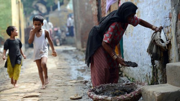 To go with story 'India-health-social-toilets' (FILES) In this photograph taken on August 10, 2012, 60 year old manual scavenger Kela collects human waste while cleaning a toilet in Nekpur village, Muradnagar in Uttar Pradesh, some 40 kms east of New Delhi. For nearly four decades, Kela Devi worked for a pittance emptying her high-caste neighbours' toilets with her bare hands in the small Indian village where she lives. But in the last two years she has turned her life around, learning to read and write and opening her first bank account. Devi is among 21 women in the village of Nekpur who managed to escape their desperate situation with the help of the charity Sulabh International, which provided shelter and a basic education.  AFP PHOTO/ Prakash SINGH/FILES