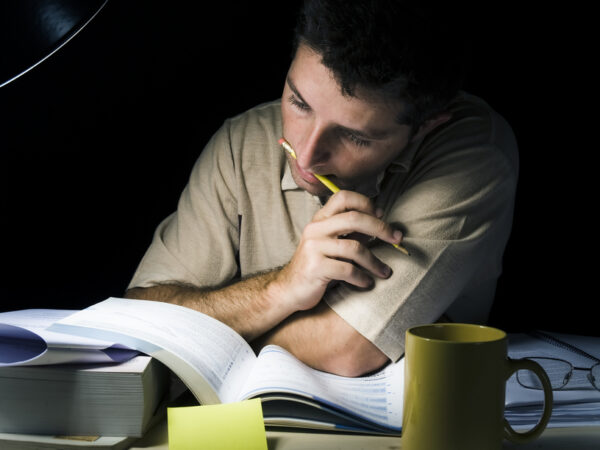 Young Man Studying at Night isolated on black background