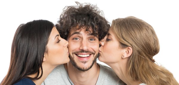 Women Kissing Man On Cheeks