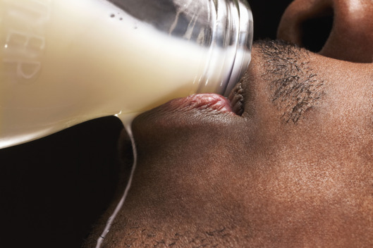 Man drinking milk from bottle, side view, detail