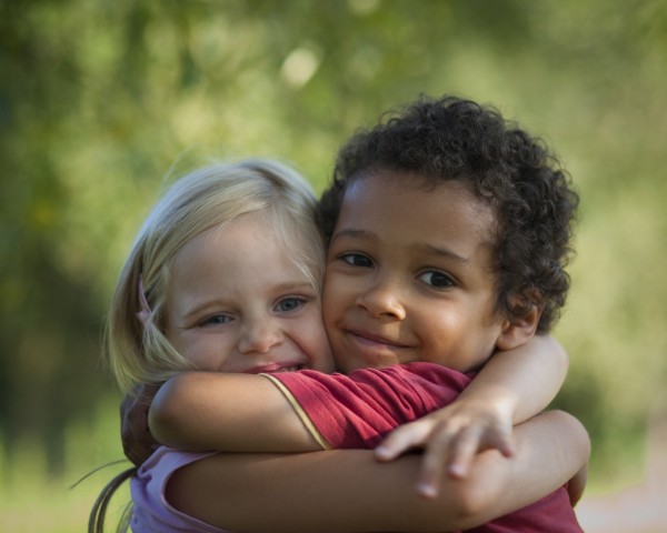 Multi-racial children hug eachother