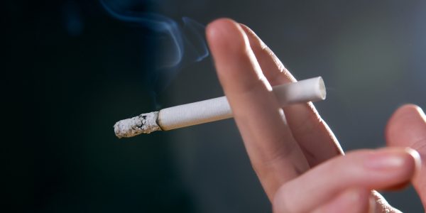 Woman's fingers with smoking cigarette macro shot