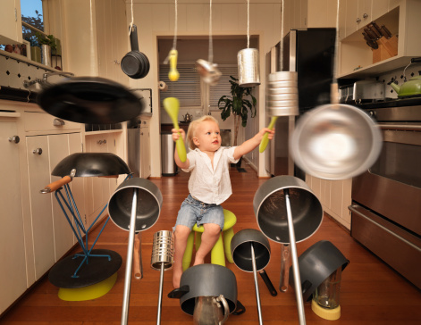 Boy playing drum set made out of household items