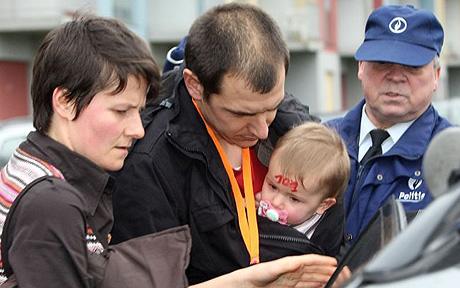 Two unidentified persons hold a child with an identification number on his forehead, at a crisis center next to the scene of a stabbing incident at a daycare center in Dendermonde, Belgium, Friday Jan. 23, 2009. It was not immediately known the motive for the incident, when a man bicycled to the day care centre, walked in and began a stabbing spree killing two youngsters, a care giver and sending 10 children to hospital. (AP Photo/Alain Sprimont)