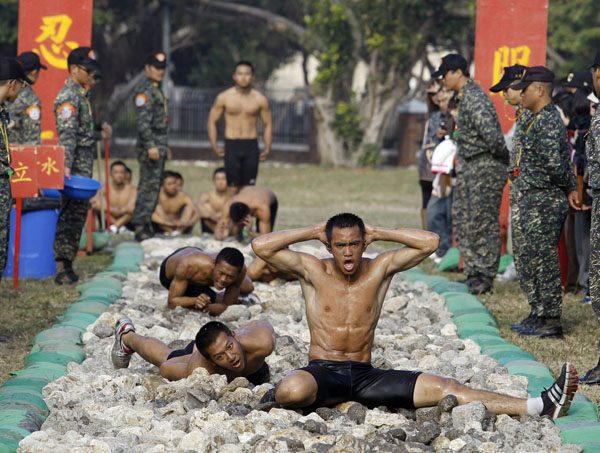 Trainees take part in the Taiwan Marines frogmen "Road to Heaven" test in Zuoying, Kaohsiung, southern Taiwan, January 19, 2011. The "Road to Heaven" test, which is the final stage of a nine week intensive Amphibious Training Program, requires trainees to execute various exercises and leopard crawl along a 50 metre long path that is littered with jagged corals and rocks. Picture taken January 19, 2011.       REUTERS/Nicky Loh (TAIWAN - Tags: MILITARY SOCIETY)