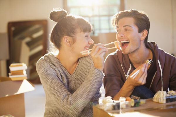 Couple eating sushi together in new home