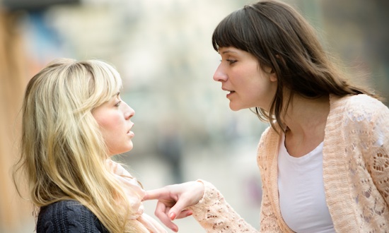 Two women talking to each other and arguing.