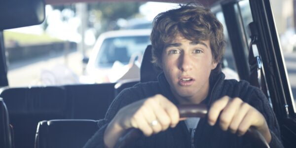 Teenage boy driving car
