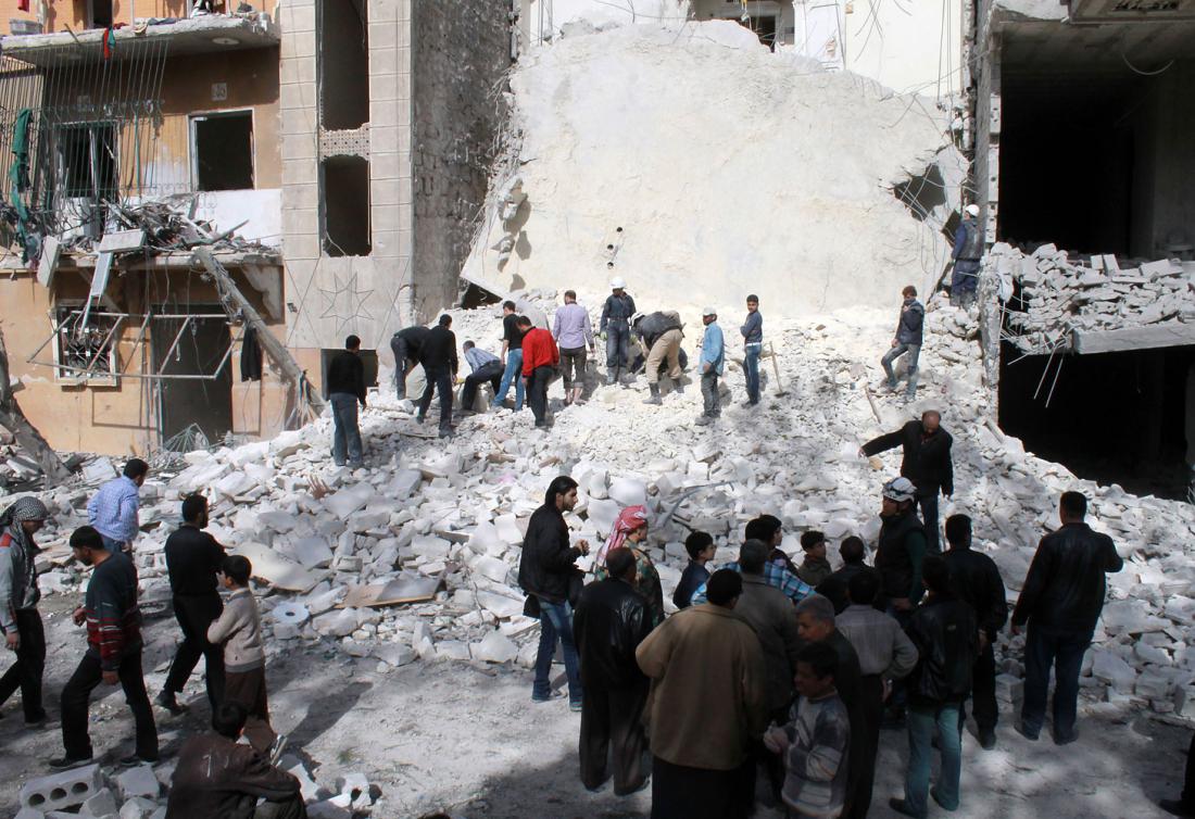 Syrians look at the destruction following an airstrike by government forces on the northern Syrian city of Aleppo on March 5, 2014. AFP PHOTO / BARAA AL-HALABI (Photo credit should read BARAA AL-HALABI/AFP/Getty Images)