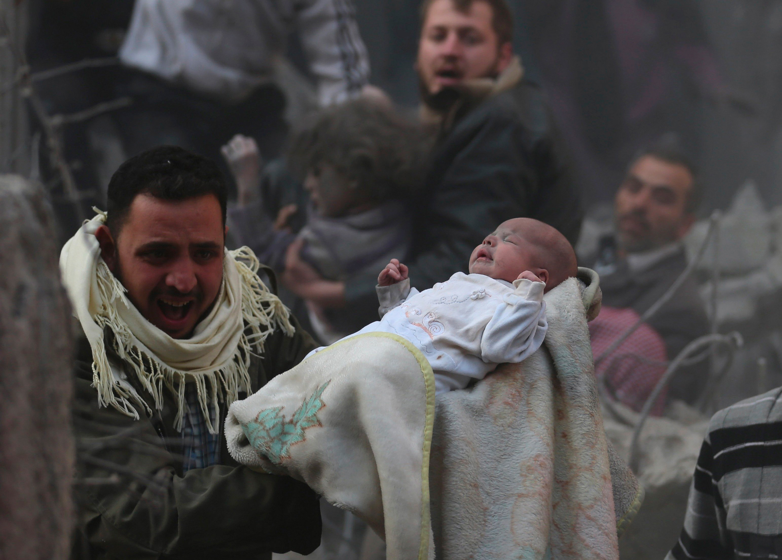 A man carries a baby who survived what activists say was an airstrike by forces loyal to Syrian President Bashar al-Assad in the Duma neighbourhood of Damascus January 7, 2014. REUTERS/Bassam Khabieh (SYRIA - Tags: POLITICS CIVIL UNREST CONFLICT TPX IMAGES OF THE DAY)