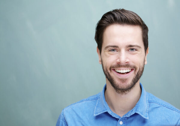 Portrait of a handsome young man with beard smiling