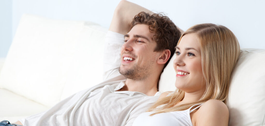 Young beautiful couple on a sofa at home