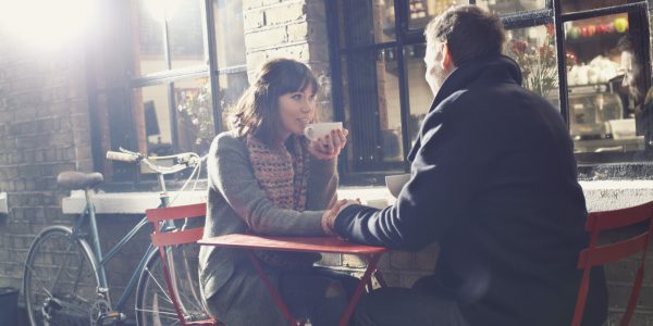 Couple having coffee at sidewalk cafe