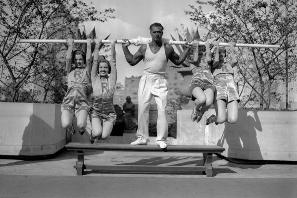 UNITED STATES - SEPTEMBER 10: Strongman Charles Atlas doing his stuff by lifting four Rockettes on the roof of Radio City Music Hall. Each girl weighs 110 lbs. Girls are [l.-r.] R. Myrna Waverly, Dorothy Collins, Lucille Bremer and Muriel Kildugf. (Photo by Bill Meurer/NY Daily News Archive via Getty Images)