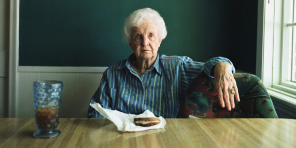 Senior woman sitting at dinning table, portrait
