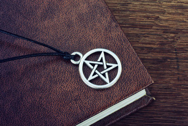 pentagram pendant lying on an old book
