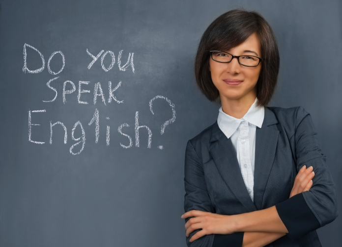 Teacher is standing near blackboard