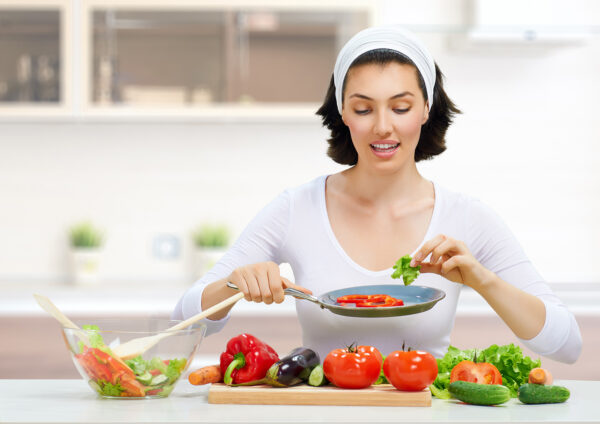 woman in kitchen making salad