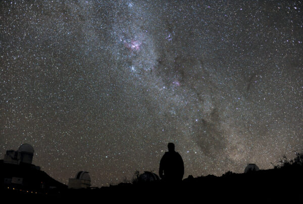 A piercingly bright curtain of stars is the backdrop for this beautiful image taken by astronomer Håkon Dahle. The silhouetted figure in the foreground is Håkon himself surrounded by just a couple of the great dark domes that litter the mountain of ESO’s La Silla Observatory. Many professional astronomers are also keen photographers — and who could blame them? ESO sites in the Atacama Desert are among the best places on Earth for observing the stars, and for the same reason, are amazing places for photographing the night sky. Håkon took these photos while on a week-long observing run at the MPG/ESO 2.2 -telescope. During this time, the telescope was occasionally handed over to a different observing team, giving Håkon the opportunity to admire the starry night — as well as to capture it for the rest of us to see. The Milky Way is brighter in the Southern Hemisphere than in the North, because of the way our planet’s southern regions point towards the dense galactic centre. But even in the South, the Milky Way in the night sky is quite faint in the sky. For most of us, light pollution from our cities and even the Moon can outshine the faint glow of the galaxy, hiding it from view. One of the best aspects of La Silla Observatory is that it is far away from bright city lights, giving it some of the darkest night skies on Earth. The atmosphere is also very clear, so there is no haze to further muddy your vision. The skies at La Silla are so dark that it is possible to see a shadow cast by the light of the Milky Way alone. Håkon submitted this photograph to the Your ESO Pictures Flickr group. The Flickr group is regularly reviewed and the best photos are selected to be featured in our popular Picture of the Week series, or in our gallery.