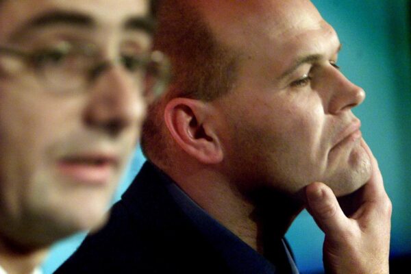 John Pluthero (R), Chief Executive Officer of British Internet service provider  'Freeserve', strokes his chin as he listens to Chairman & Chief Executive Officer of  'Wanadoo'  Nicolas Dufourcq during a news conference in Central London December 6, 2000. Shares in Freeserve and Wanadoo were suspended today pending an announcement that the biggest French and British internet companies were finalising a merger. - RTXK5U6