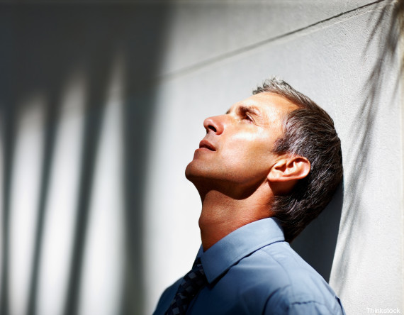 Depressed mature businessman leaning on wall