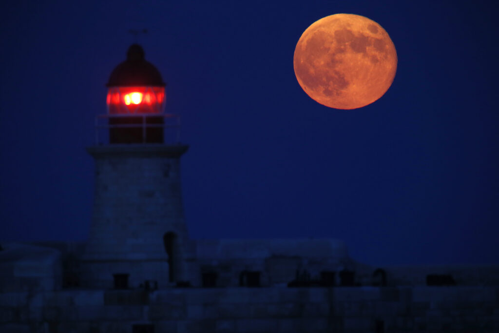 The full moon rises behind the lighthouse on the breakwater of Valletta's Grand Harbour September 9, 2014. The September full moon, also known as the Harvest Moon, is the last of this summer's three supermoons, and the final one of the year. REUTERS/Darrin Zammit Lupi (MALTA - Tags: ENVIRONMENT SOCIETY) MALTA OUT. NO COMMERCIAL OR EDITORIAL SALES IN MALTA - RTR45LBR