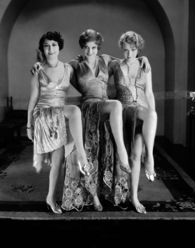 8th April 1928: From left to right, Dorothy Sebastian (1903 - 1957), Joan Crawford (1904 - 1977) and Anita Page live the high life in the silent film 'Our Dancing Daughters', directed by Harry Beaumont. The three women co-starred in two follow-up films, 'Our Modern Maidens' and 'Our Blushing Brides'.