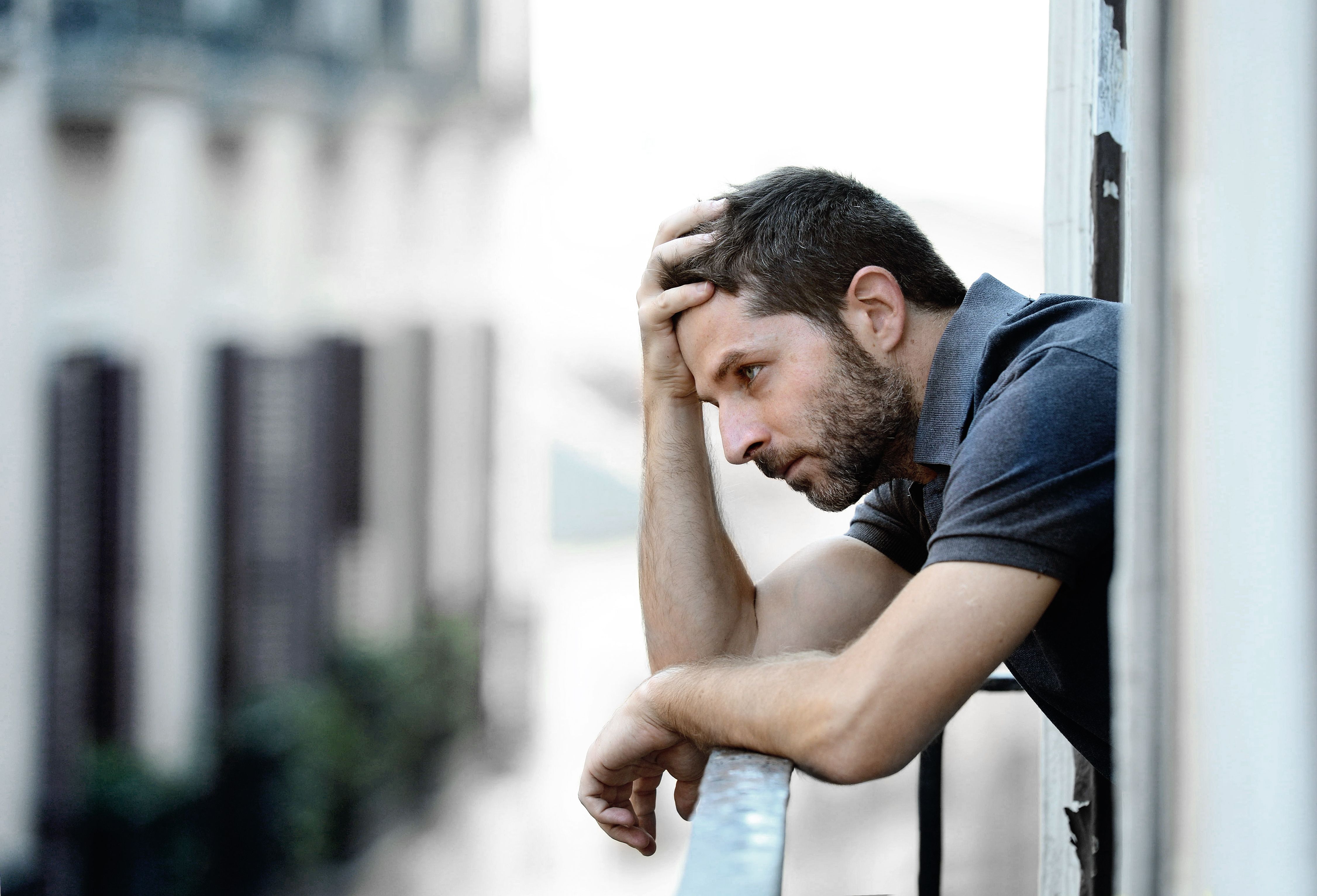 Young Man At Balcony In Depression Suffering Emotional Crisis An