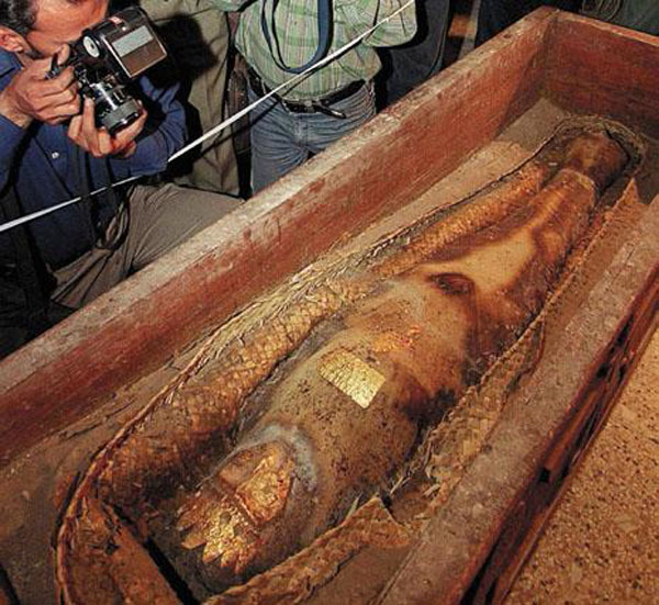 Original Caption: Pakistani photographers hover over an ancient mummy show for the first time, during a press conference at the National Museum in Karachi, 26 October 2000. The mummified "princess" in a gold-studded casket could have originated in Egypt or Iran before appearing on Pakistan's blackmarket.  AFP PHOTO/Aamir QURESHI