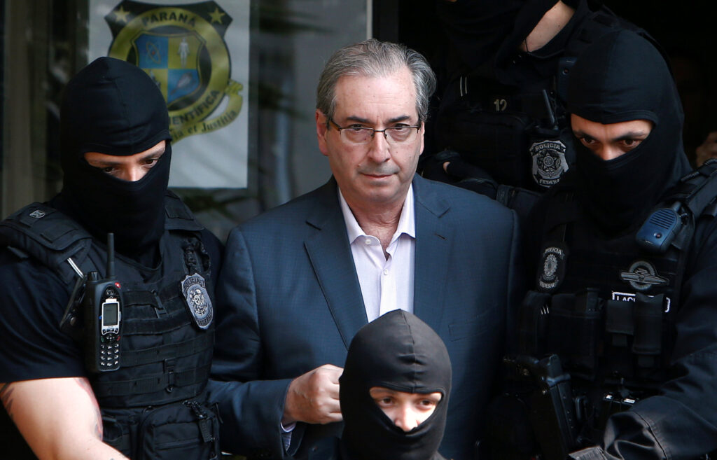 Former speaker of Brazil's Lower House of Congress, Eduardo Cunha (C), is escorted by federal police officers as he leaves the Institute of Forensic Science in Curitiba, Brazil, October 20, 2016. REUTERS/Rodolfo Buhrer