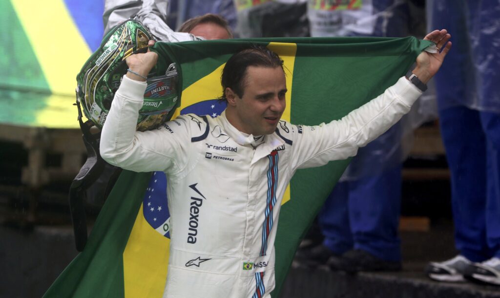 Formula One - F1 - Brazilian Grand Prix - Circuit of Interlagos, Sao Paulo, Brazil - 13/11/2016 - Williams' Felipe Massa of Brazil carries his country's flag after he had to withdraw from the race due to car problems. REUTERS/Paulo Whitaker