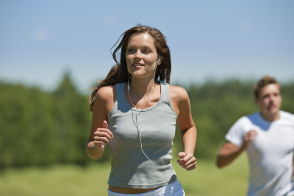 Brown hair woman with headphones jogging